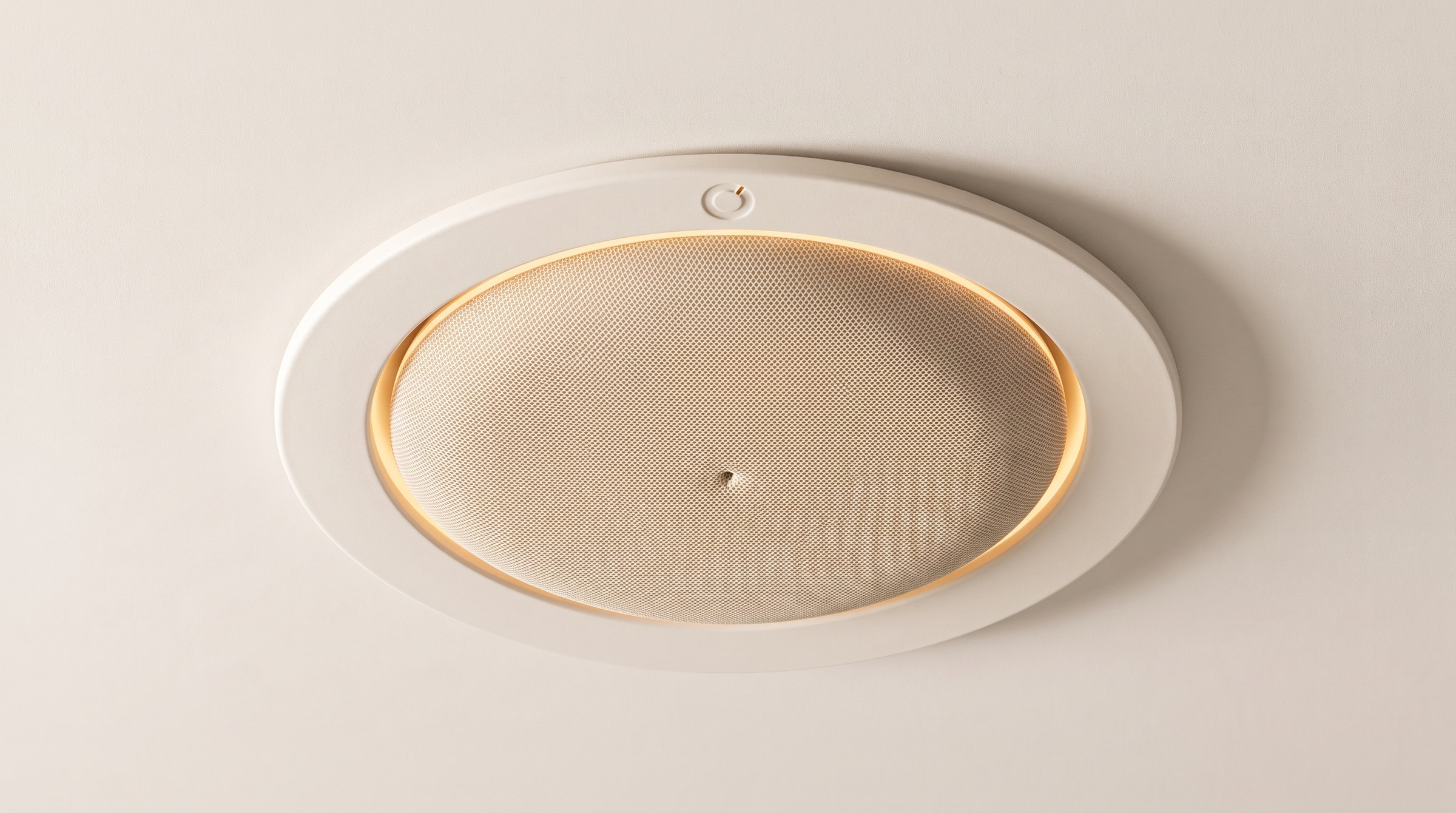 The Fall Sense unit seen from below: a warm white ceramic bezel flush with the ceiling, an oat mesh face, an amber ring of light at the rim and a single pinhole at the centre